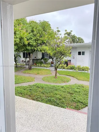 a view of a house with a backyard and a tree