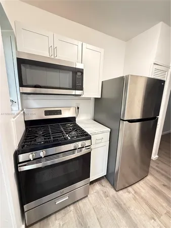 a stove top oven sitting inside of a kitchen