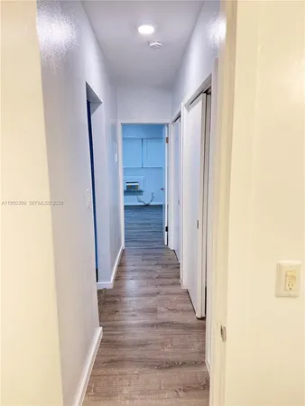 a view of a hallway with wooden floor