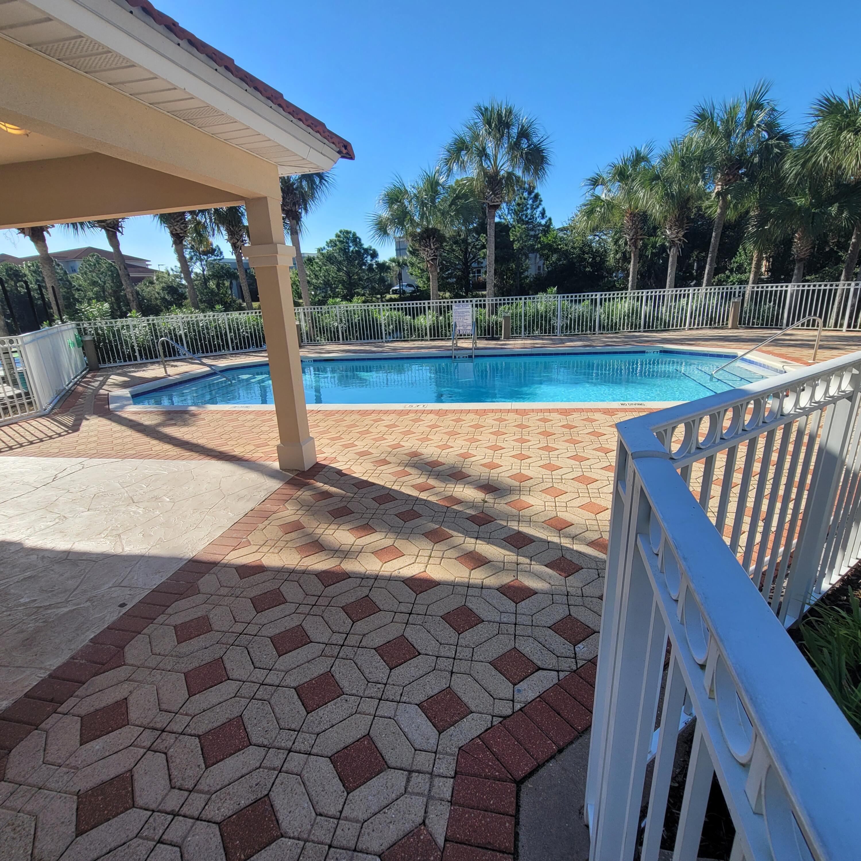 235 Inverrary Drive Destin, FL 32541 - Photo 6 of 8 a view of a backyard with table and chairs under an umbrella