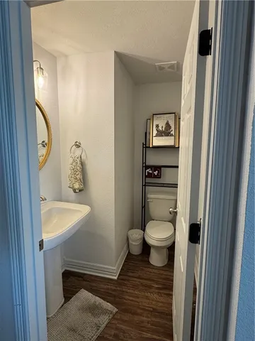 a bathroom with a toilet a sink and mirror