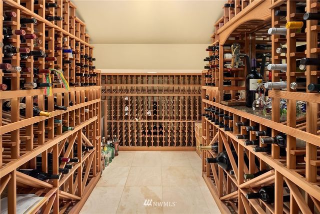 a view of patio with couches table and chairs under an umbrella with large trees