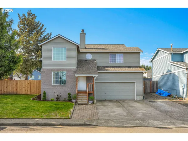 a front view of a house with a yard and garage