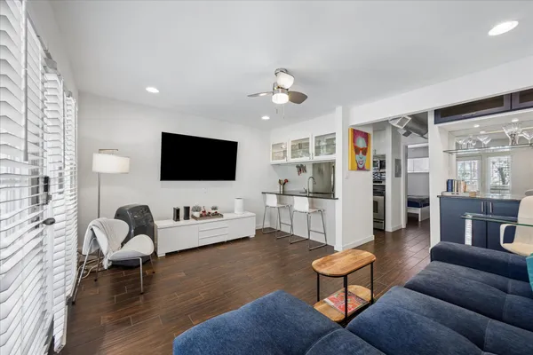 a living room with furniture flat screen tv and wooden floor