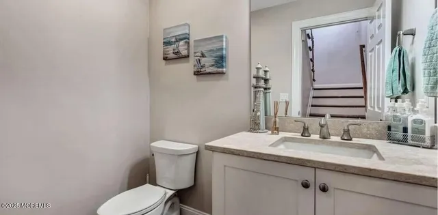 a bathroom with a granite countertop toilet sink and mirror