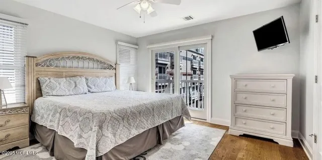 a bedroom with a large bed and a flat tv screen on dresser