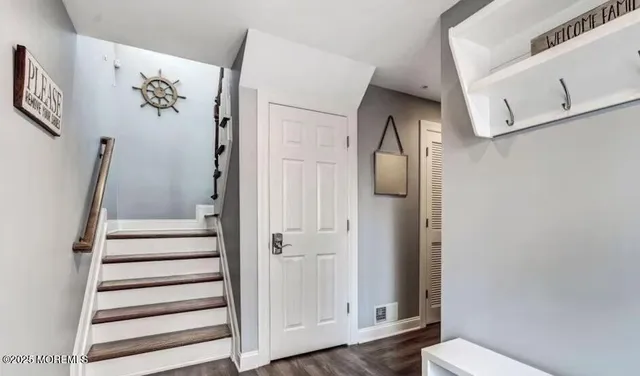 a view of a hallway with wooden floor and entryway