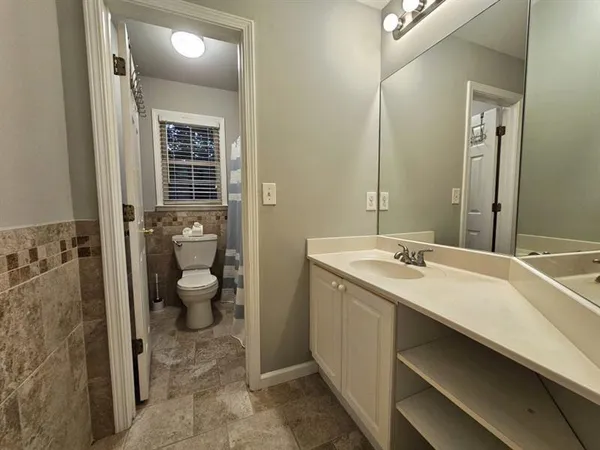 a spacious bathroom with a granite countertop sink a toilet and shower