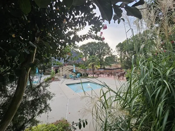 a view of a swimming pool with a patio and garden