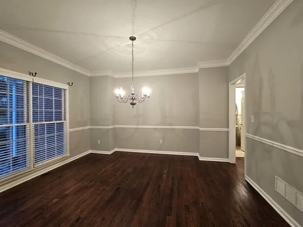 a view of a room with wooden floor entryway and a chandelier