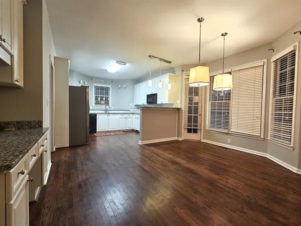 a view of a kitchen with a stove top oven a sink cabinets and wooden floor