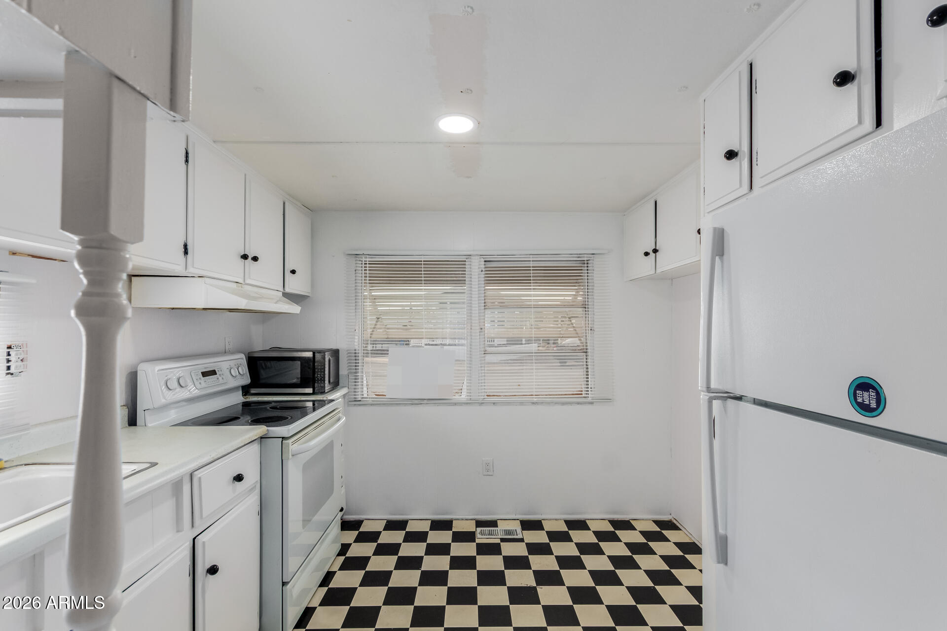 2434 East Main Street, Unit 123 Mesa, AZ 85213 - Photo 13 of 29 a kitchen with a refrigerator and white cabinets