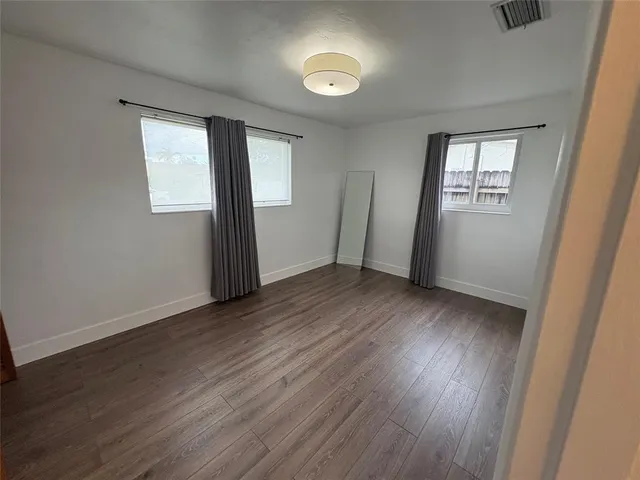 a view of wooden floor and windows in a room