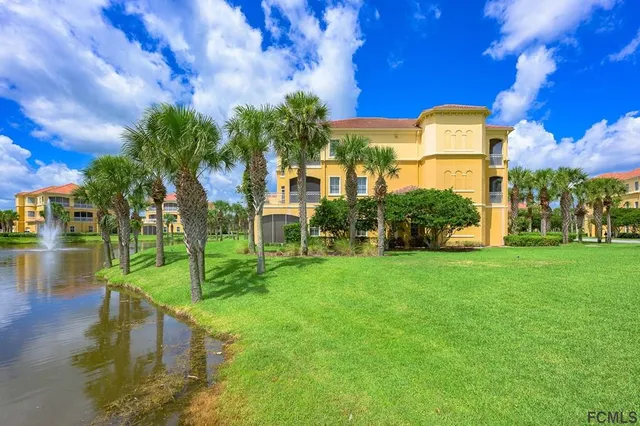 a view of a fountain in front of a house with a big yard