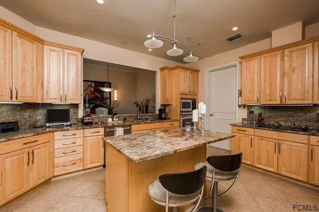a kitchen with a stove a sink a dining table and chairs