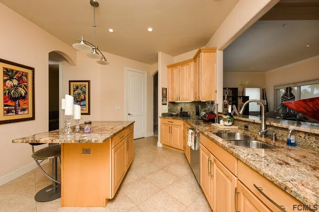 a large kitchen with kitchen island granite countertop a sink and a stove top oven