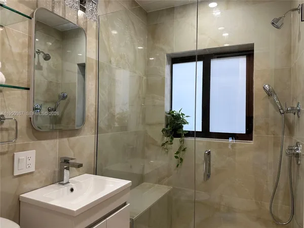 a bathroom with a sink a mirror and a shower