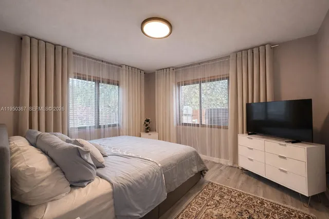 a bedroom with a flat screen tv and a window