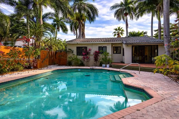 a view of a house with swimming pool and a chairs