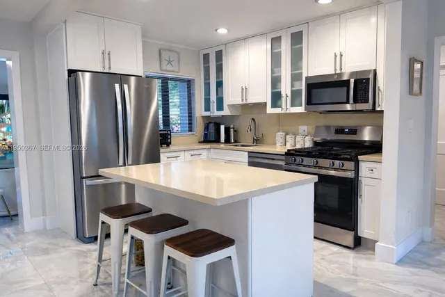 a kitchen with stainless steel appliances a stove a refrigerator and a microwave