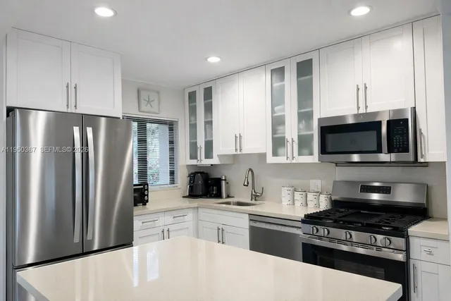 a kitchen with stainless steel appliances granite countertop a refrigerator stove top oven and sink