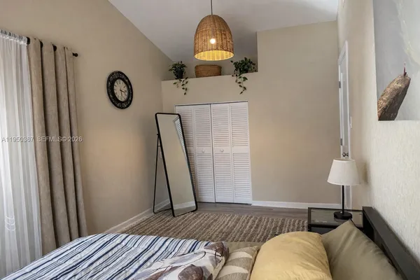 a bedroom with a bed and a lamp on the dresser