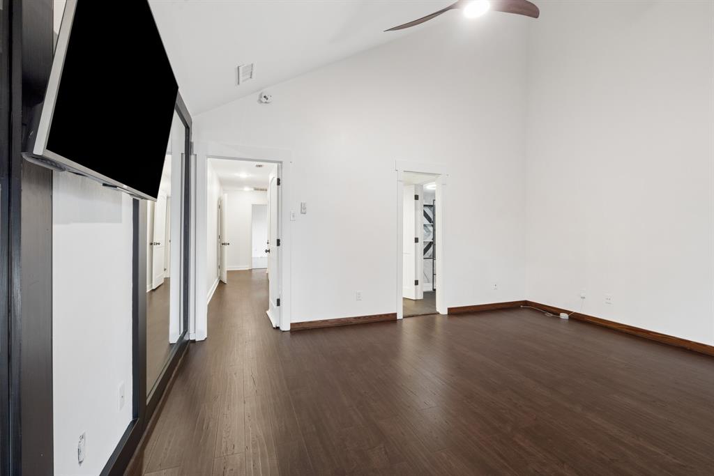 15539 Preston Road, Unit 1037 Dallas, TX 75248 - Photo 24 of 36 Vaulted ceiling with a ceiling fan, dark wood-finish flooring, and white walls