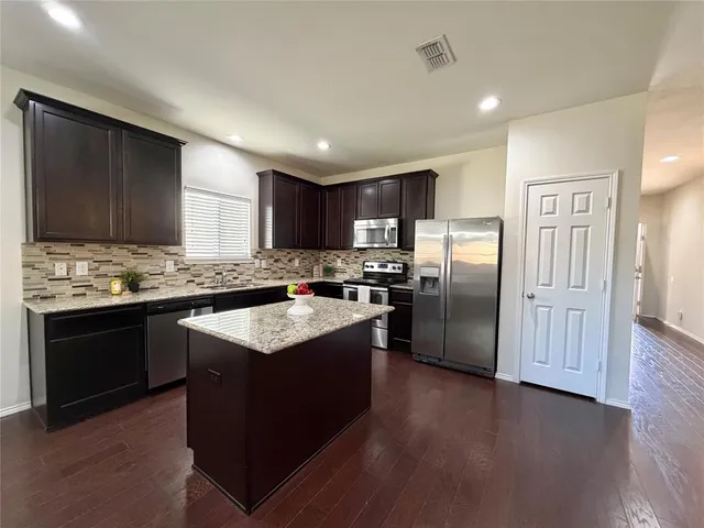 a kitchen with granite countertop stainless steel appliances and wooden cabinets