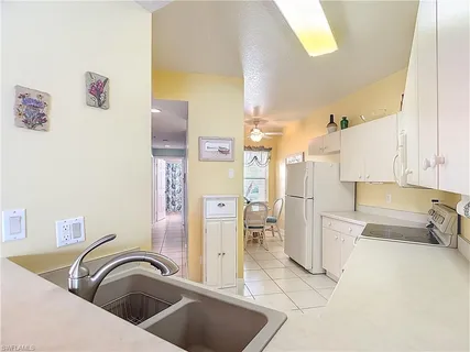 a kitchen with a refrigerator sink and cabinets