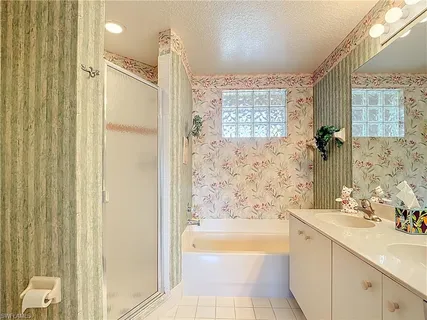 a bathroom with a granite countertop sink a mirror a bathtub and shower