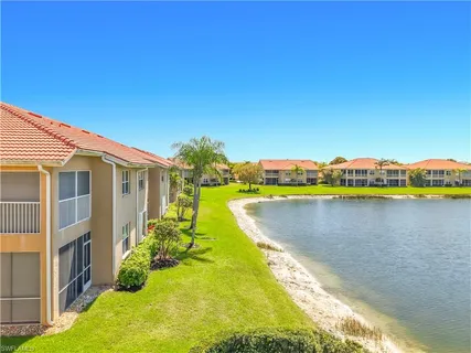 a view of a house with a yard and a lake view