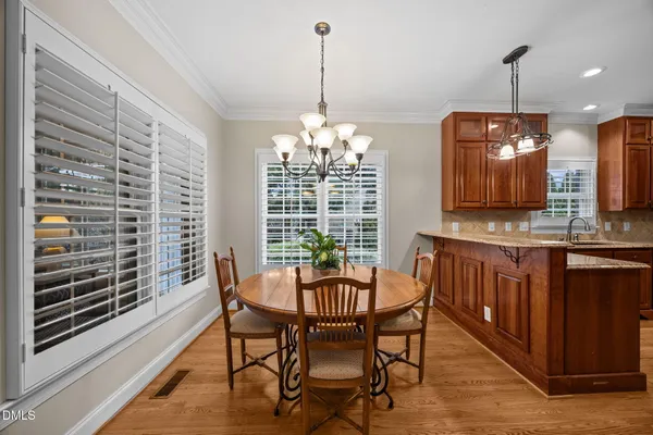 a dining room with furniture a chandelier and wooden floor