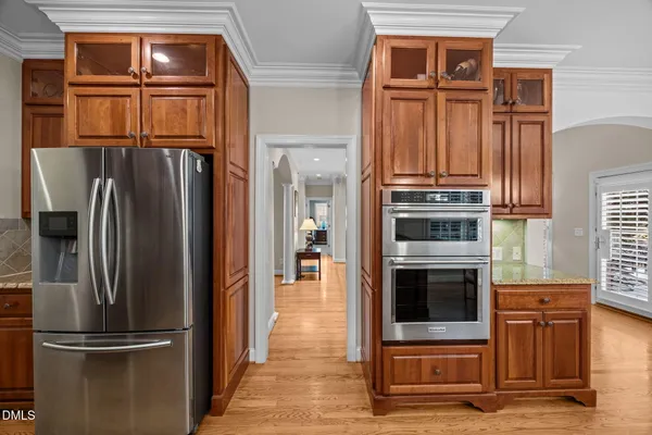 a metallic refrigerator freezer sitting inside of a kitchen