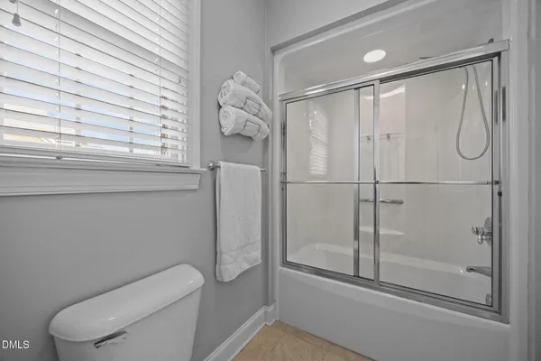 a bathroom with a granite countertop sink a toilet and a mirror