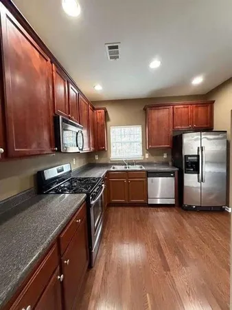a kitchen with granite countertop stainless steel appliances and wooden cabinets