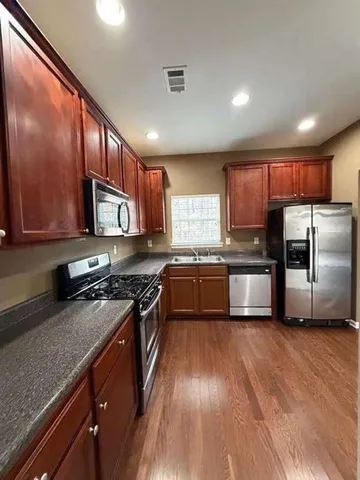 a kitchen with granite countertop stainless steel appliances and wooden cabinets