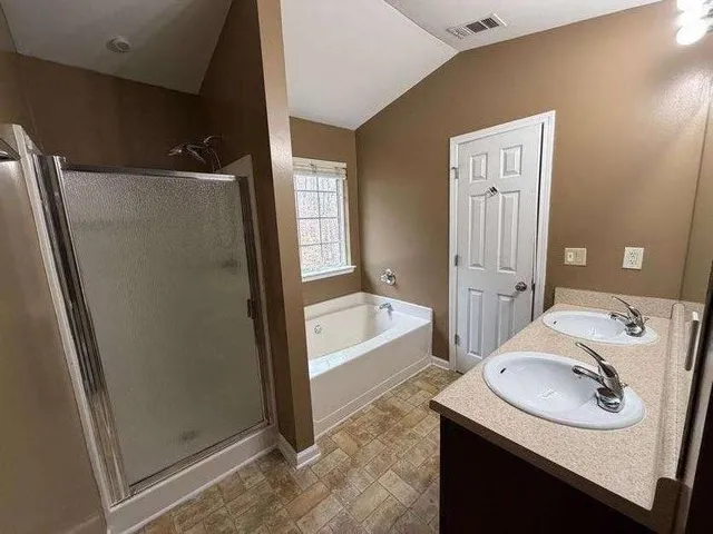 a bathroom with a granite countertop sink and a bathtub