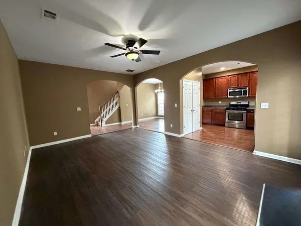 a view of a room with wooden floor chandelier and windows