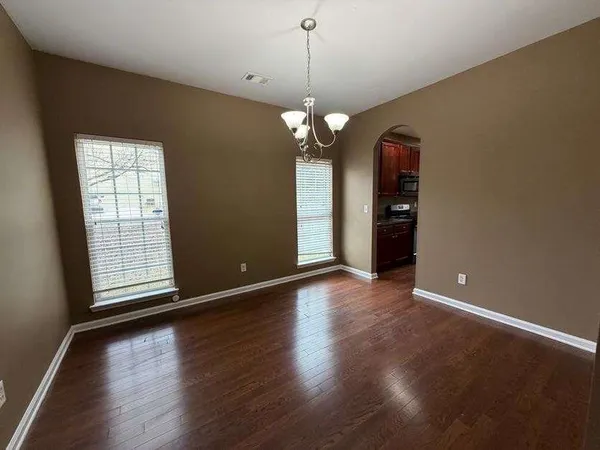 a view of a room with wooden floor and chandelier