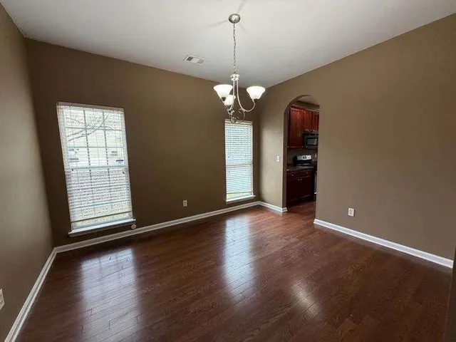 a view of a room with wooden floor and chandelier