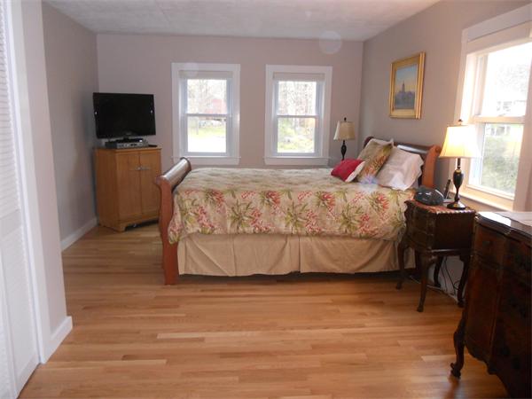 500 Marrett Road Lexington, MA 02421 - Photo 9 of 16 a bedroom with a bed and flat tv screen on the dresser