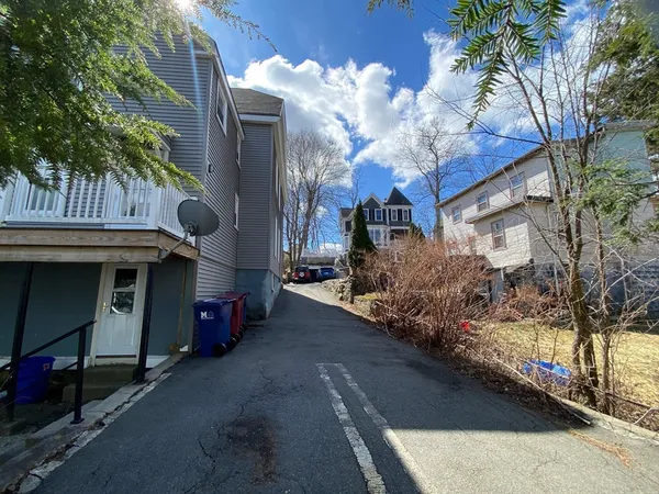 a view of a street in cars park both side of building