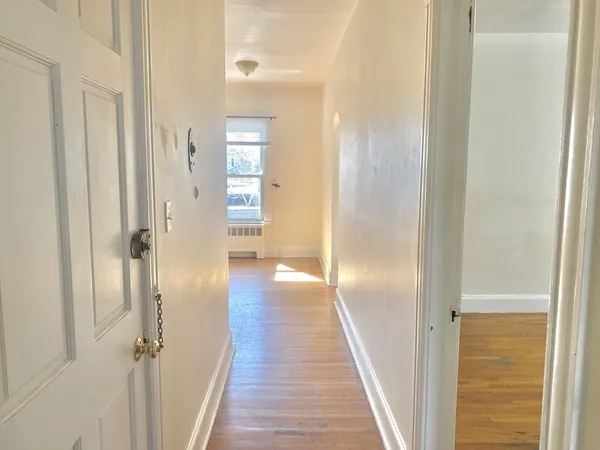 a view of a hallway with wooden floor