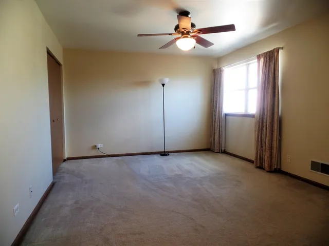 an empty room with fan and windows