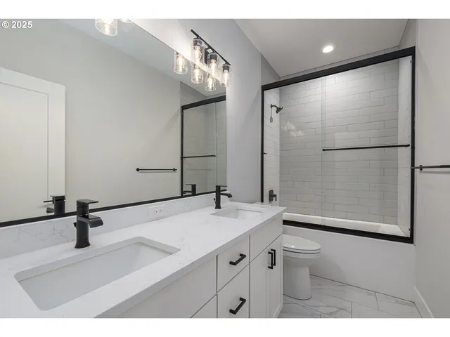 a bathroom with a sink a toilet a mirror and shower