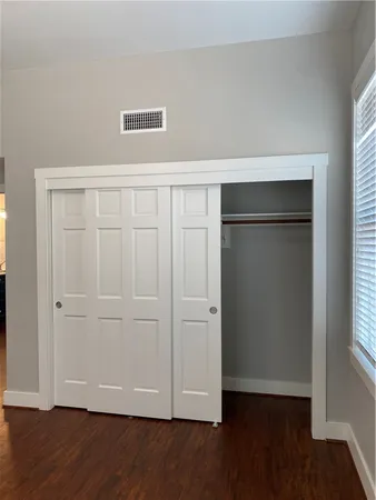 an empty room with wooden floor and closet