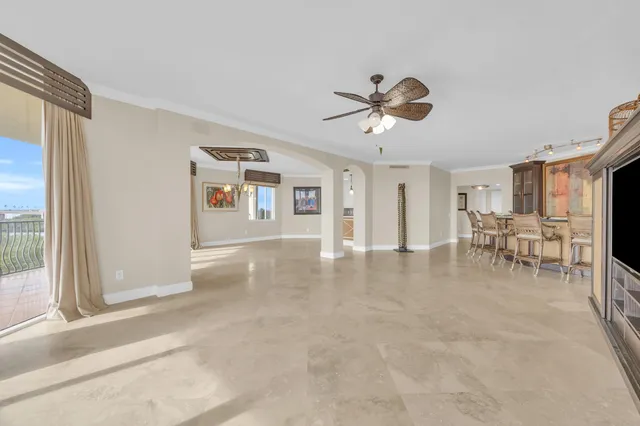 a dining hall with stainless steel appliances kitchen island granite countertop a table chairs and a refrigerator