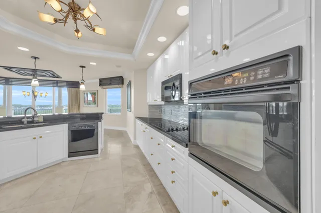 a kitchen with stainless steel appliances granite countertop a sink cabinets and wooden floor