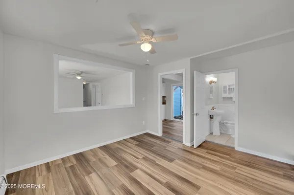 a view of a livingroom with wooden floor and a ceiling fan