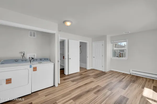 a view of a kitchen with a sink and dishwasher with wooden floor